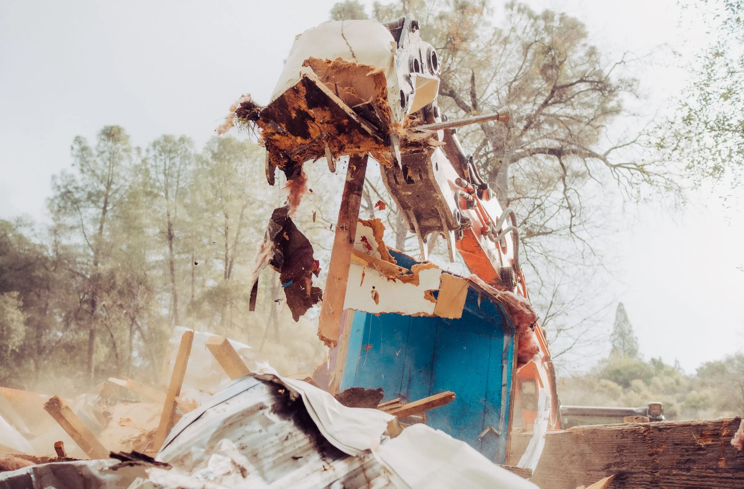 Demo Patrol grapple lifting a section of a mobile home during removal