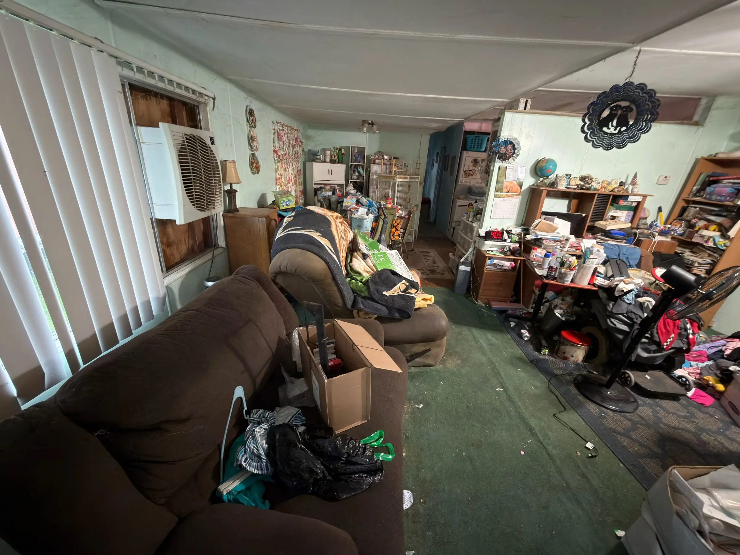Mobile home interior still full of furniture and belongings before cleanout