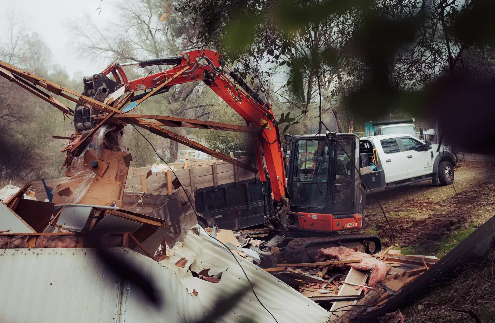 Kubota excavator tearing down a mobile home at a mobile home park demolition job